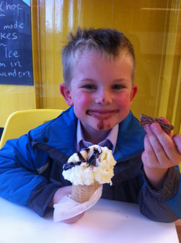 Cute little boy enjoying a Rays Ice Cream cone with chocolate sauce